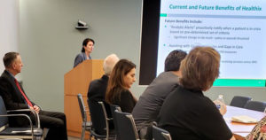 Joan Clark presenting at a podium to a room of even attendees